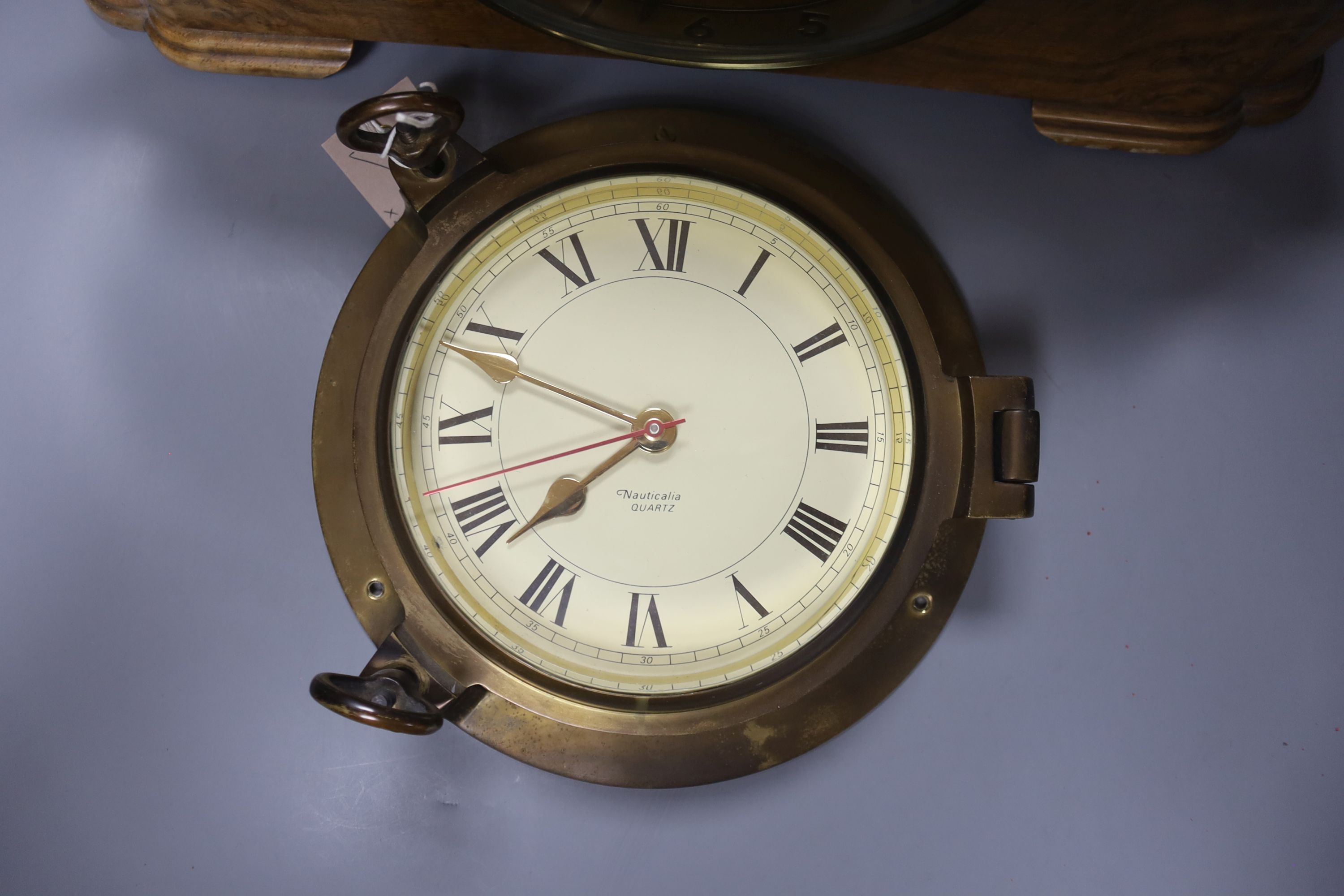 A 1920's walnut cased mantle clock, 42cm wide, 14cm deep, 22cm high and a brass bulkhead wall clock, 22cm diameter.